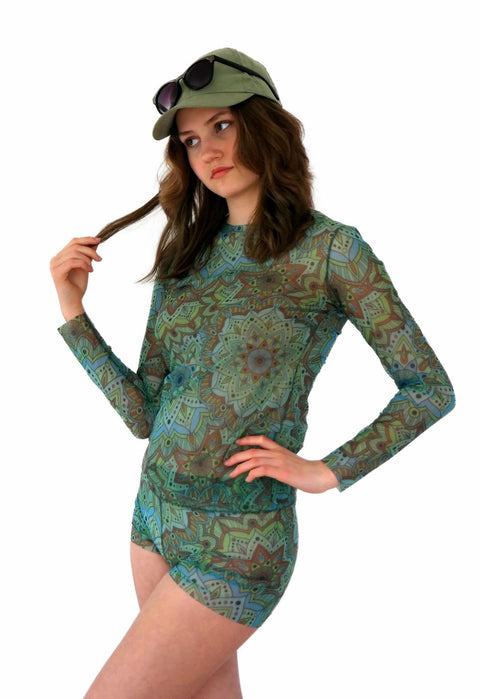 1. Women's tan-through long sleeve shirt in green mandala pattern by Smarttan, worn by model with matching shorts and cap, showcasing breathable and stretchy fabric
