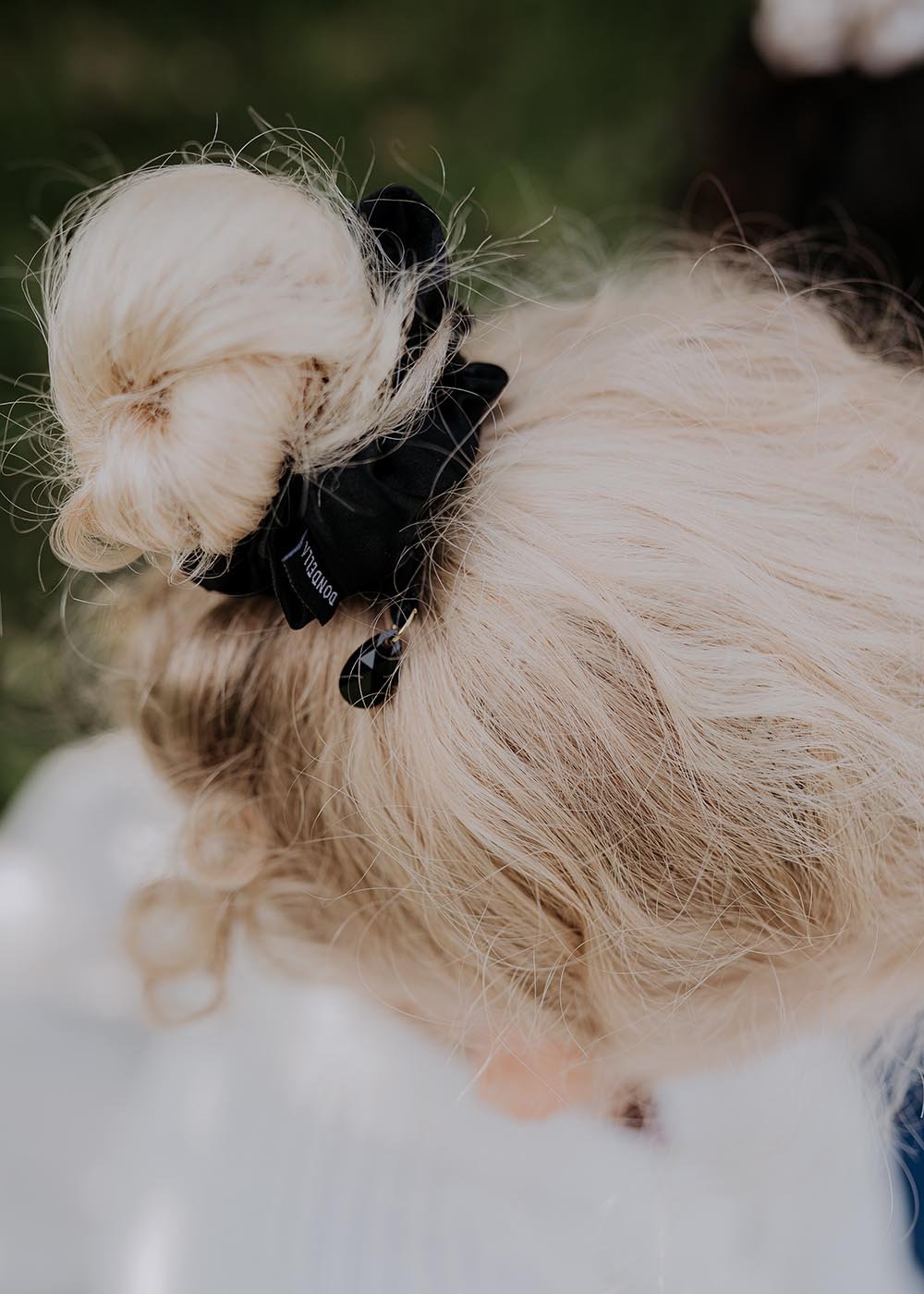 2. Woman wearing Dondella luxury black silk scrunchie in a bun, highlighting elegant hair accessory
