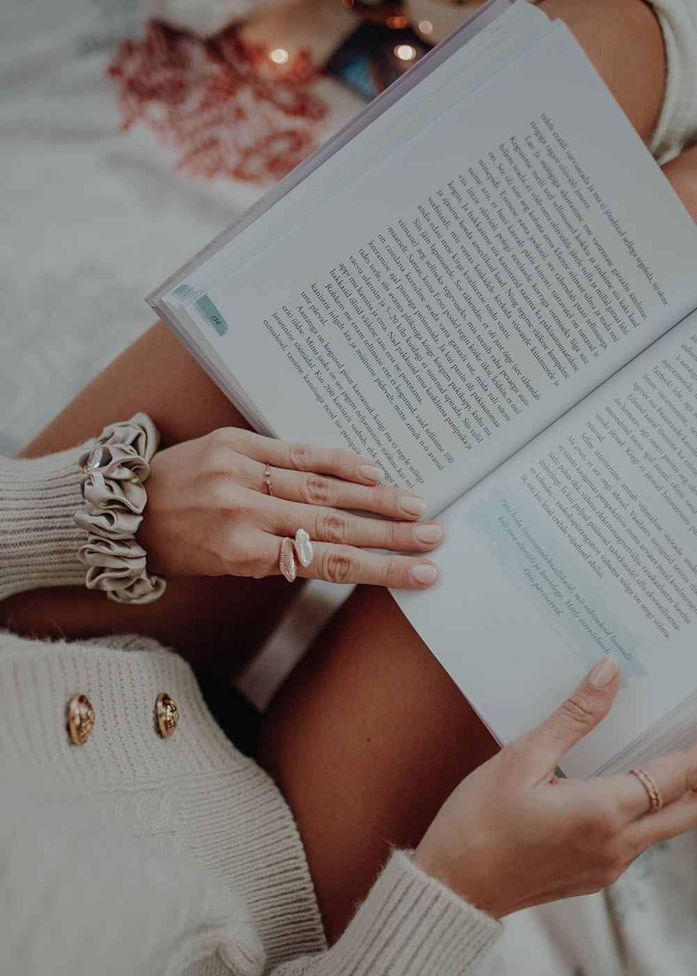 3. Dondella luxury silk scrunchie in beige worn as a bracelet while reading a book