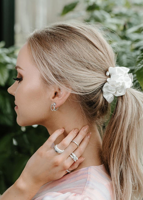 1. Woman wearing Dondella Mulberry Silk Scrunchie in Pearl, styled in a ponytail, showcasing elegant hair accessory