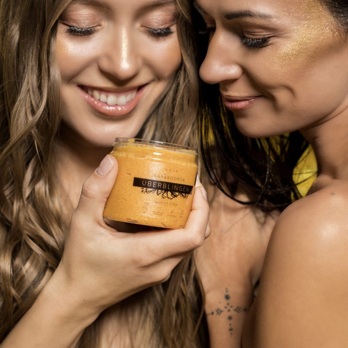 1. Two women holding HOIA homespa Shimmering Body Scrub Überblingen, showcasing glowing skin