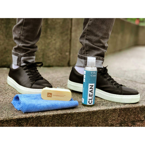 3. GoGoNano shoe cleaner gel with brush and cloth next to black sneakers on pavement