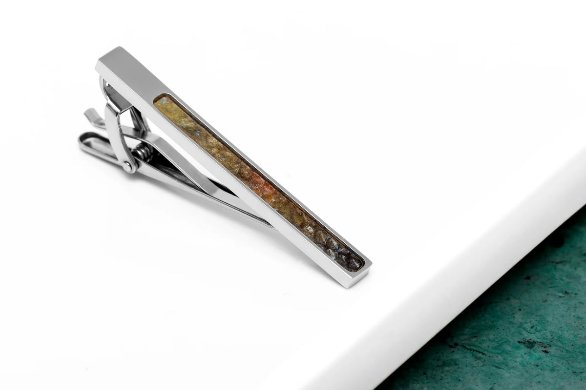 4. Handmade tie clip featuring brown trout leather inlay on white and green background