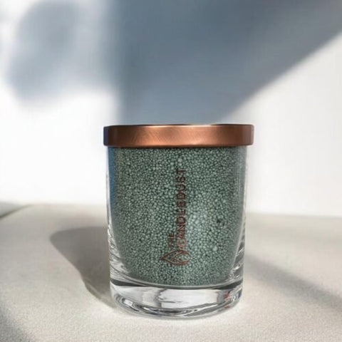2. Candledust emerald powder candle in glass with copper lid, shown in natural light