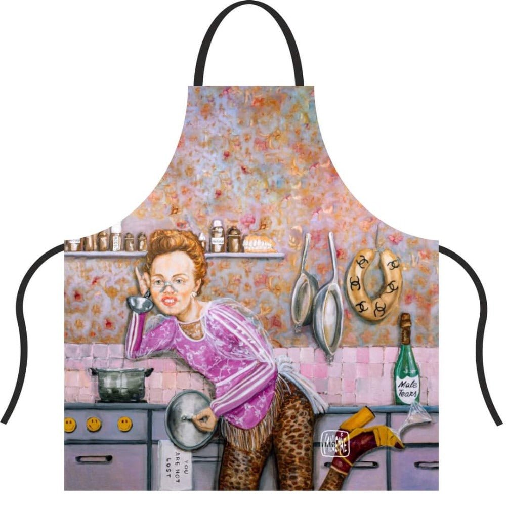 3. Close-up of Katrin Valgemäe apron featuring pop art kitchen scene with woman in pink top and leopard print pants, surrounded by kitchen items and humorous details