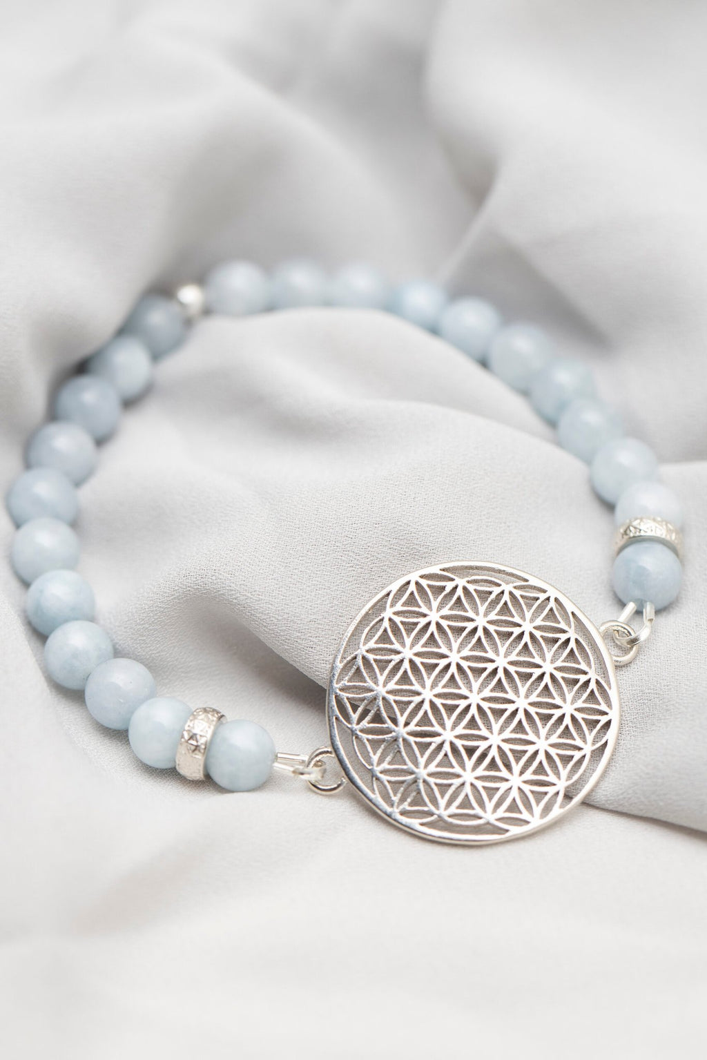 4. Close-up of New Vintage by Kriss Flower Of Life Bracelet in aquamarine with 925 silver medallion on soft fabric