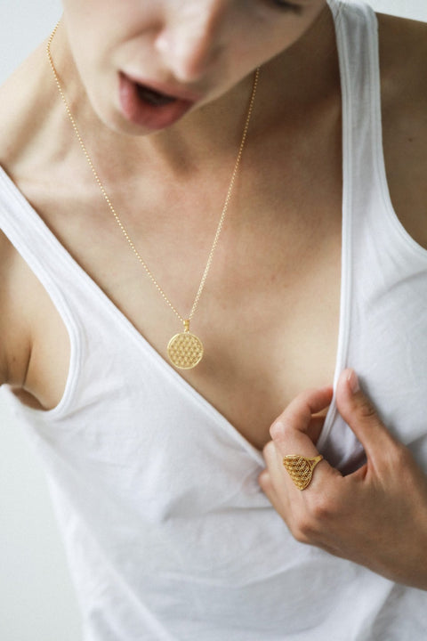 3. Woman wearing New Vintage by Kriss Flower Of Life necklace in gold with matching ring