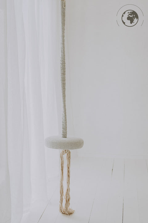 2. Ice grey bouclé swing with cotton rope hanging in a minimalistic white room
