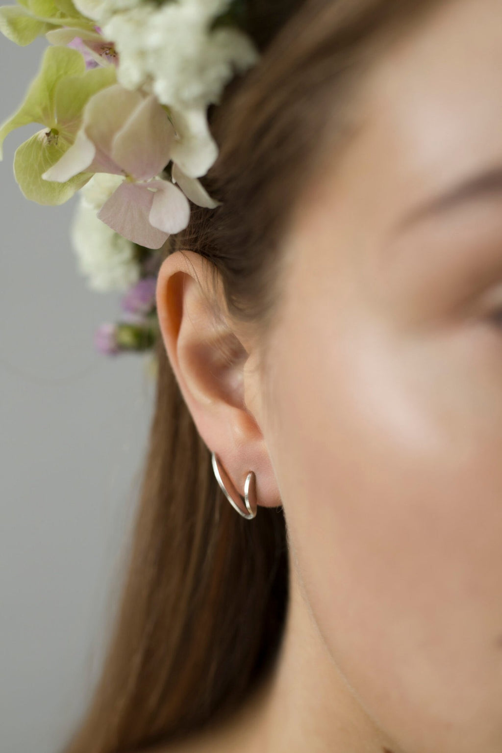 2. Close-up of Alas Upcycled Earrings by Lentsius on woman's ear, highlighting eco-friendly stainless steel craftsmanship