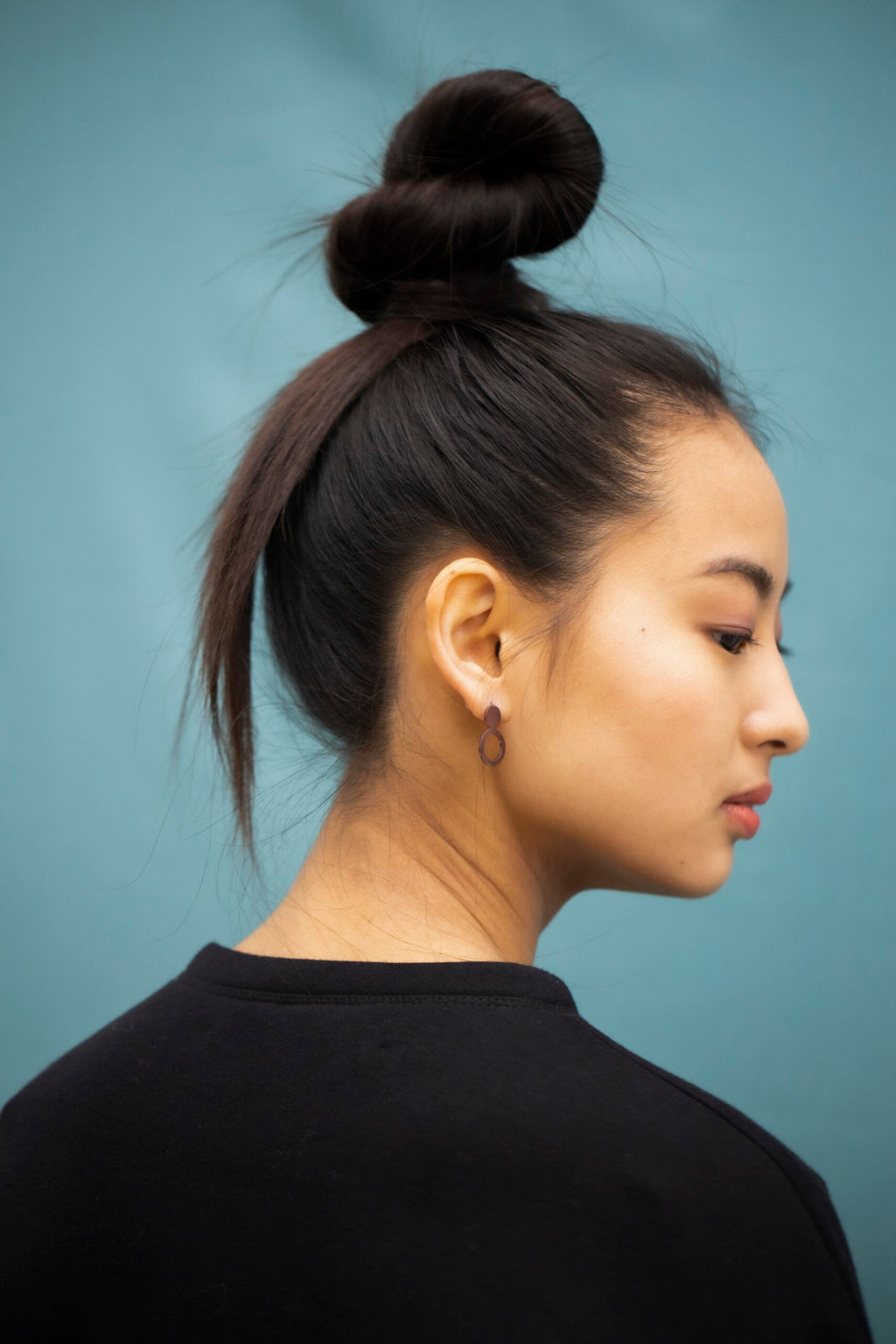4. Woman with Lentsius Arc Purple earrings, shown from the back, highlighting brushed surface finish