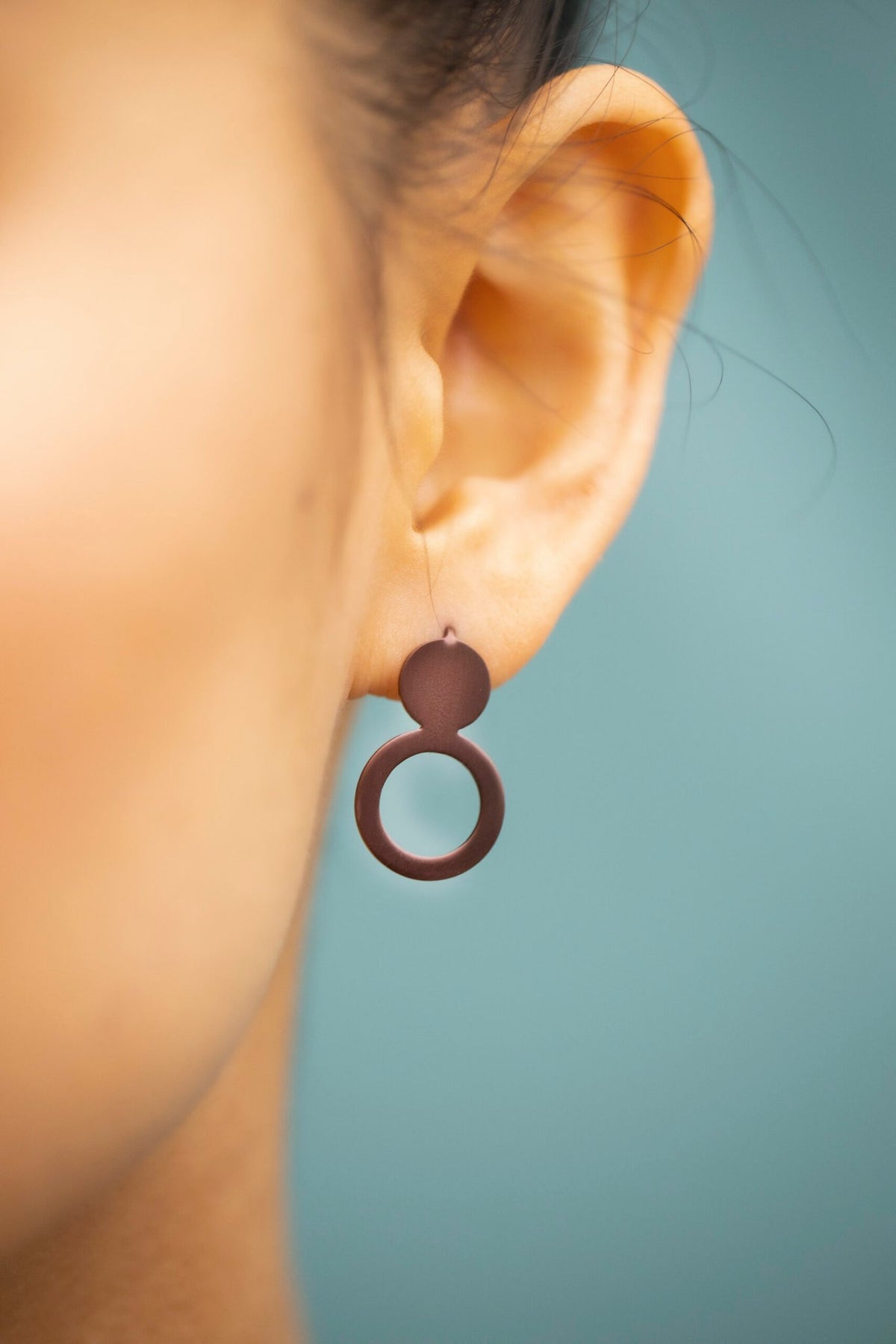 8. Close-up of Lentsius Arc Purple earring, showing brushed surface and PVD coating