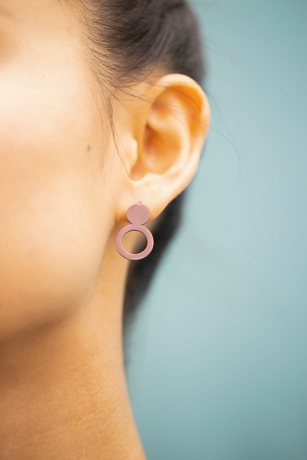 7. Close-up of Lentsius Arc Purple earring on woman's ear, highlighting innovative design