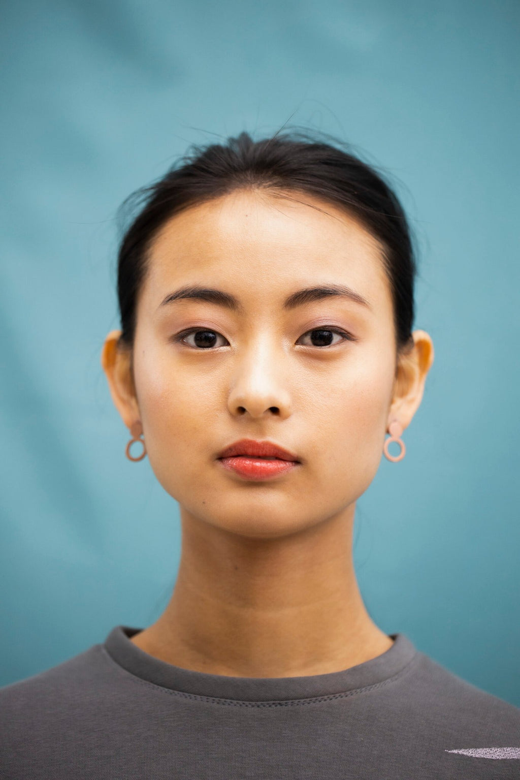 3. Front view of woman wearing Lentsius Arc rose gold earrings, emphasizing modern design and elegance