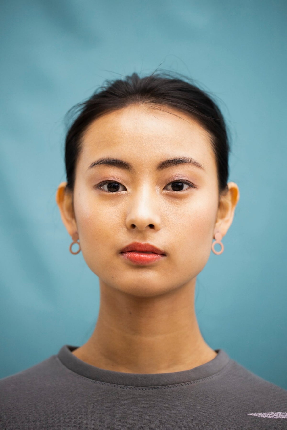 3. Front view of woman wearing Lentsius Arc rose gold earrings, emphasizing modern design and elegance