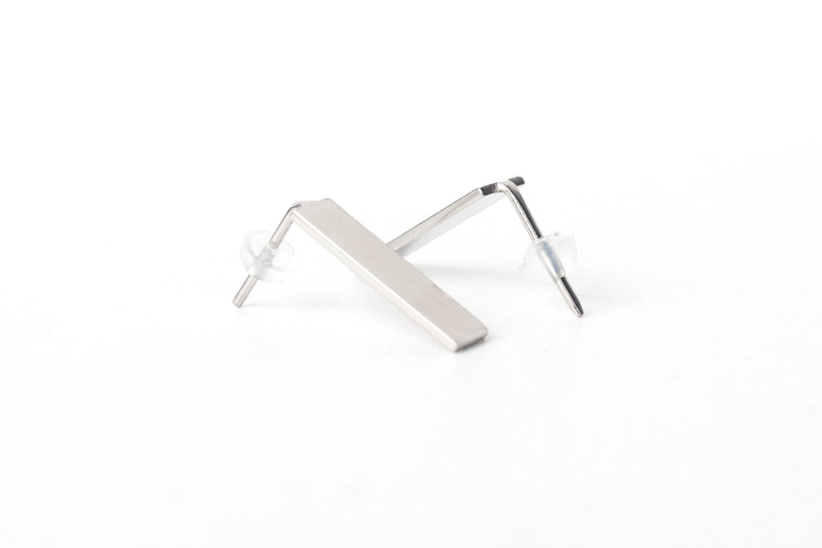 4. Close-up of Lentsius Corner silver earrings, showing hypoallergenic stainless steel and secure silicone stoppers