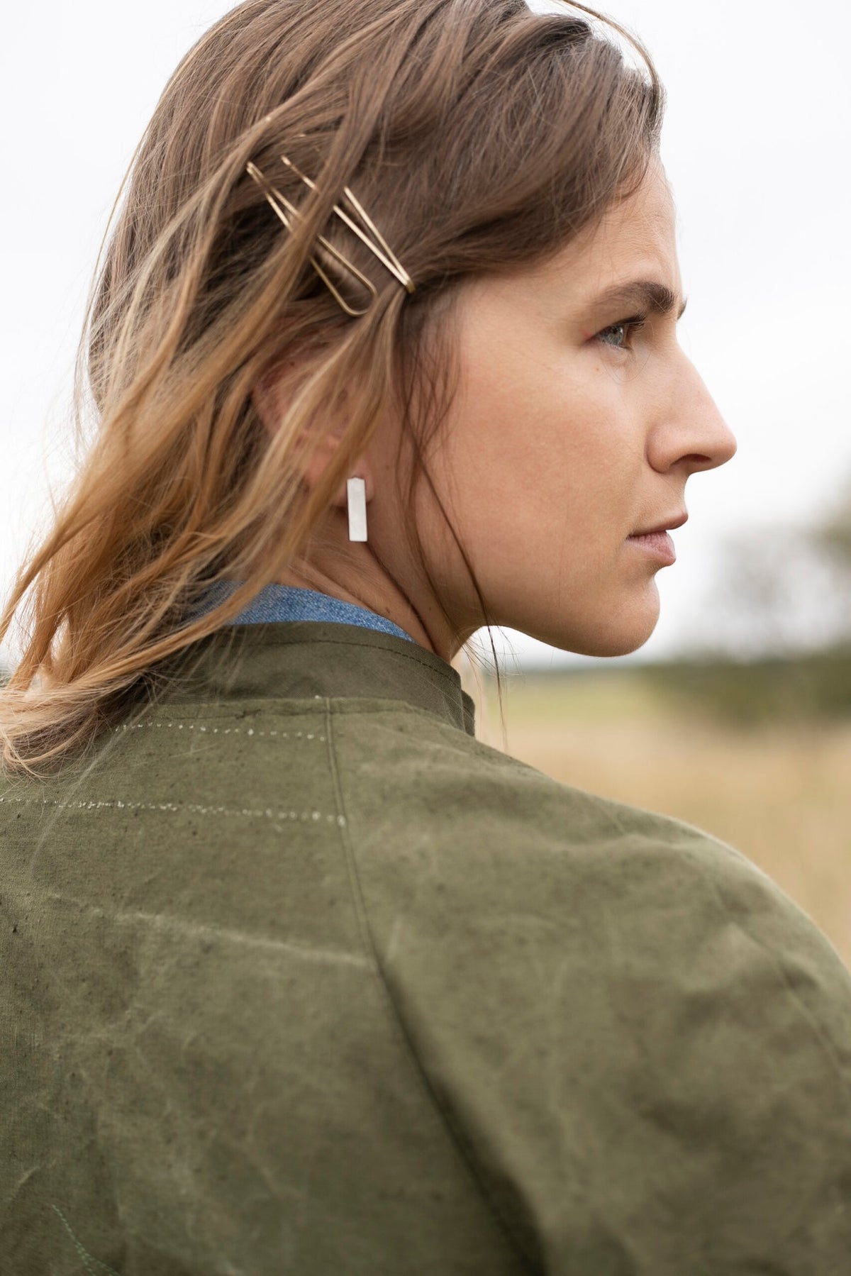 1. Women's Lentsius Corner silver earrings worn outdoors, showcasing sustainable design with brushed stainless steel finish