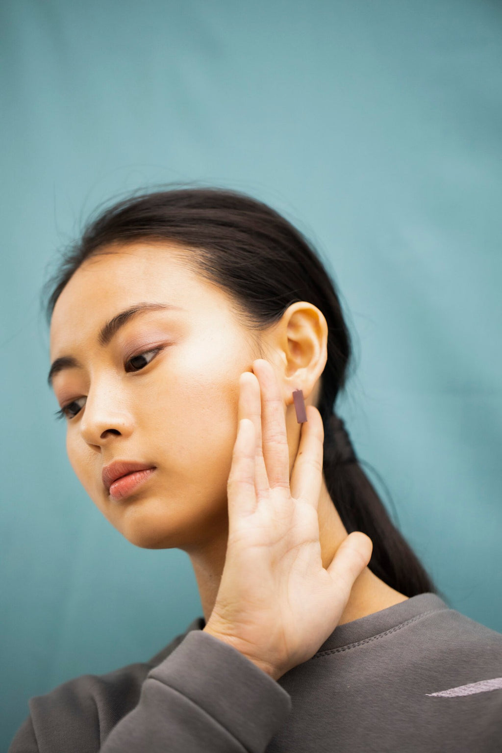 2. Close-up of woman wearing Lentsius Corner Purple earrings, highlighting brushed finish and eco-friendly craftsmanship