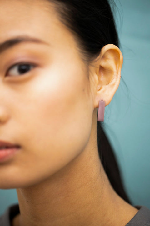 5. Close-up of Lentsius Corner Purple earring on woman, featuring upcycled industrial materials