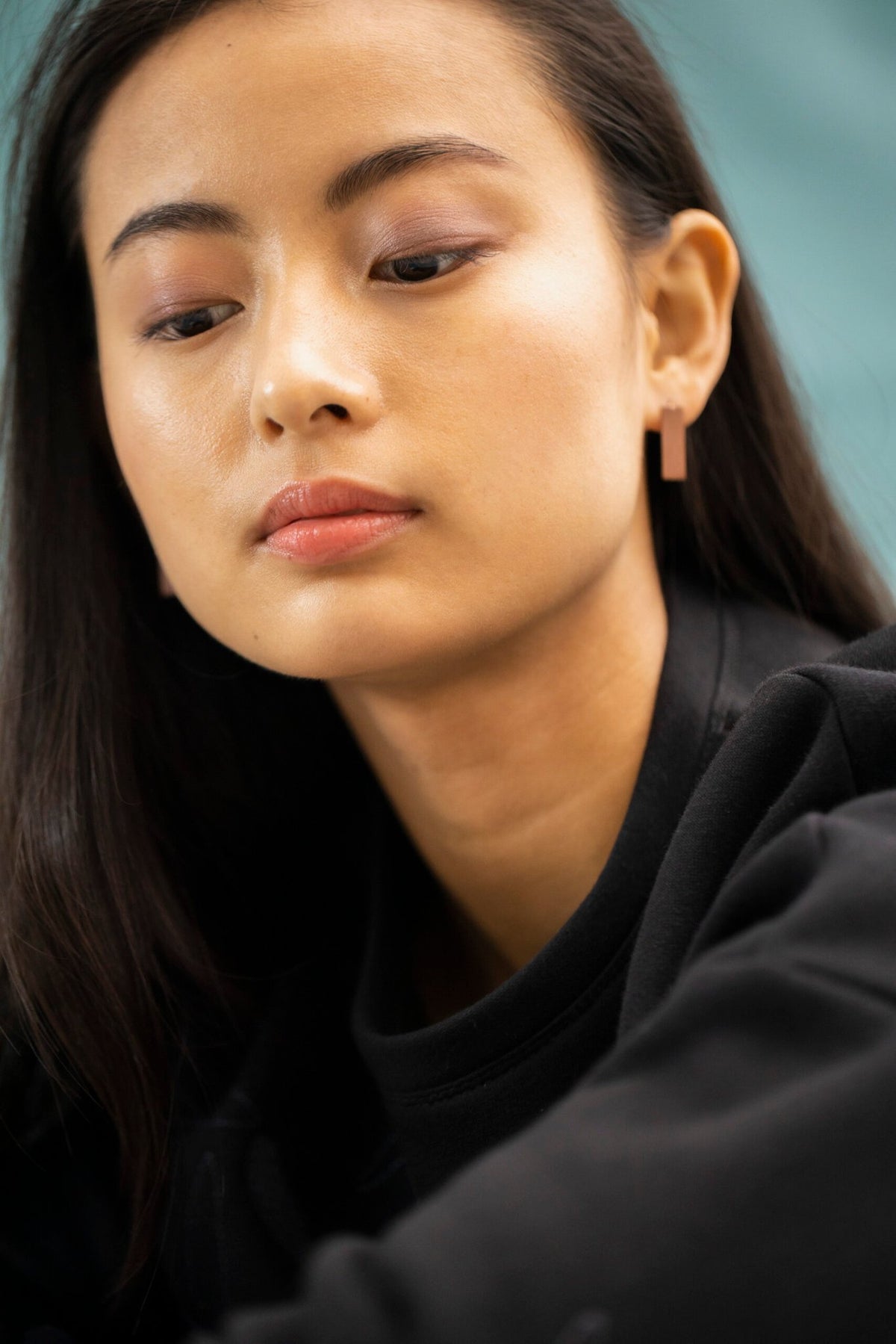 7. Woman wearing Lentsius Corner rose gold earrings, emphasizing minimalist style