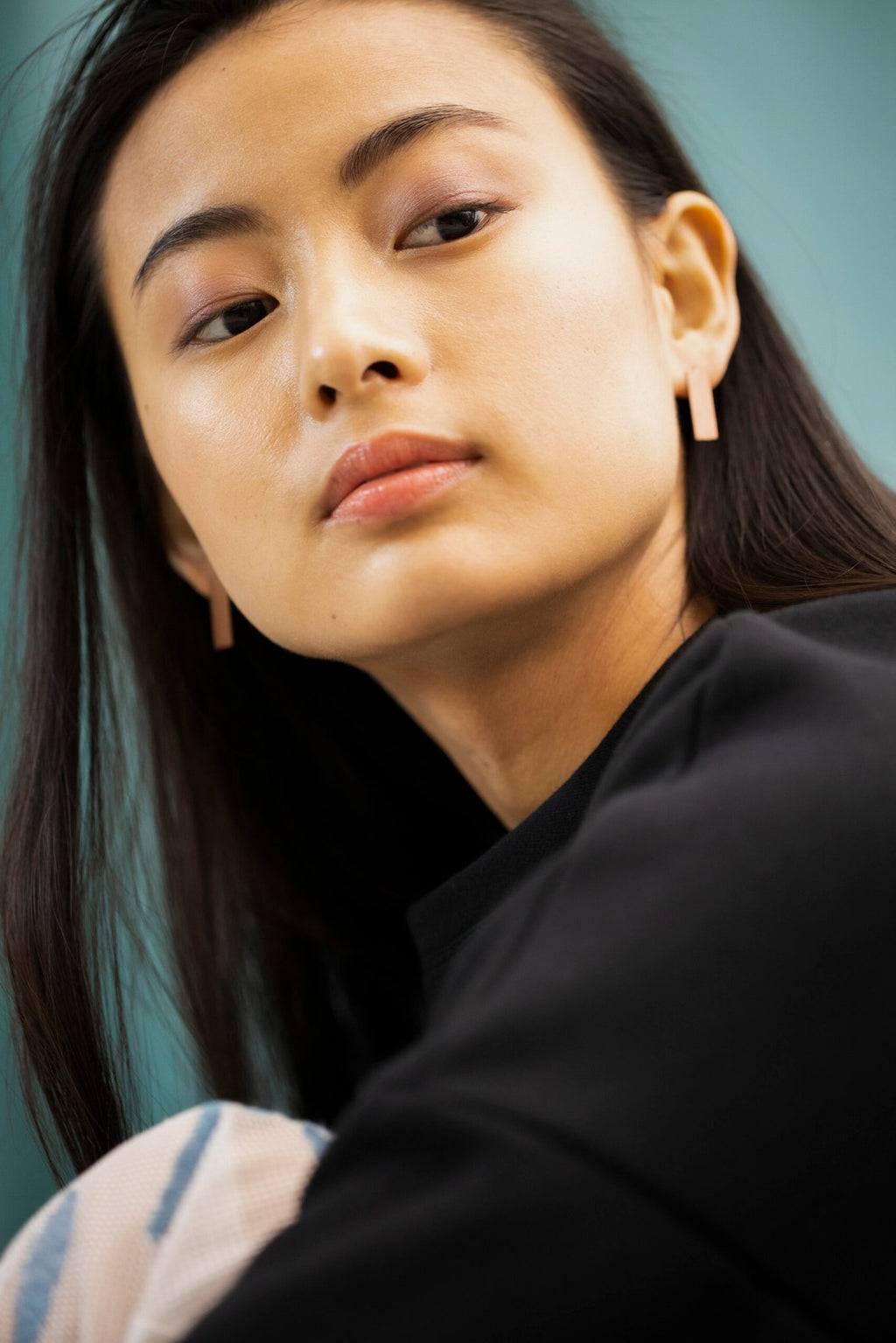 3. Woman wearing Lentsius Corner rose gold earrings, emphasizing eco-conscious style