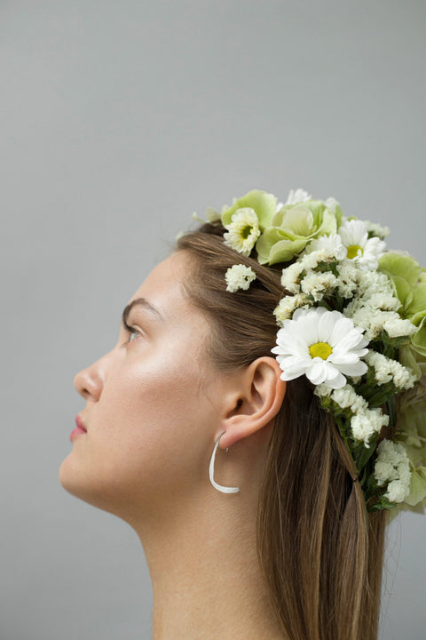 3. Side profile of woman with Lentsius Curvi earrings and floral headpiece, emphasizing sustainable craftsmanship