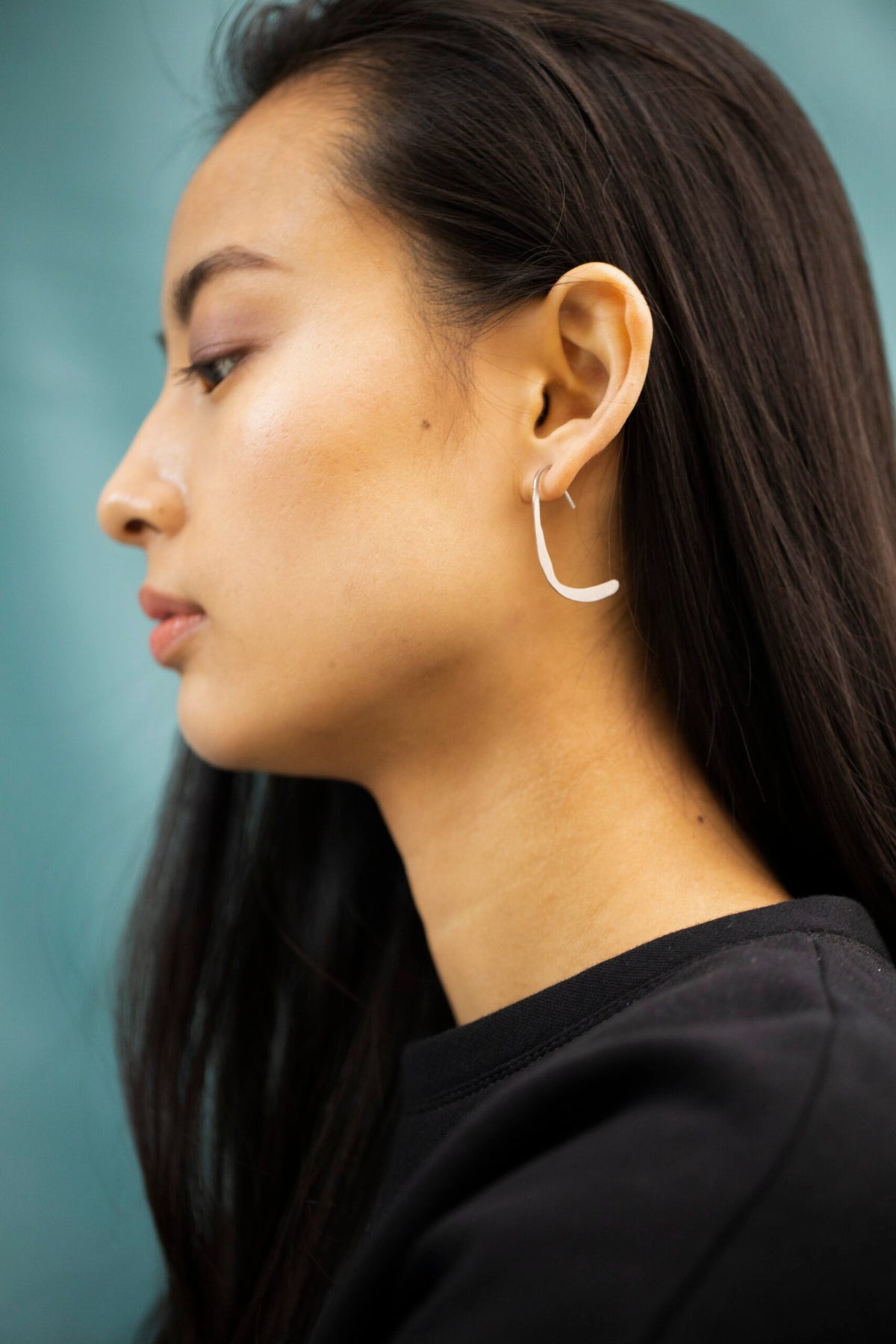 7. Profile of woman with Lentsius Curvi earrings, emphasizing upcycled industrial materials