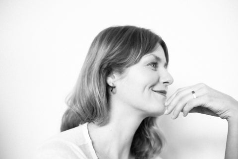 3. Smiling woman wearing Lentsius Flecte earrings, emphasizing elegant craftsmanship