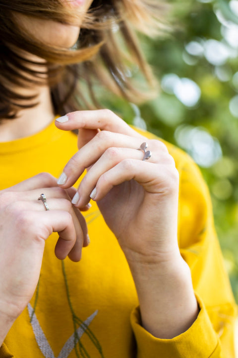 2. Close-up of woman's hands wearing Lentsius Auris ring, highlighting modern design