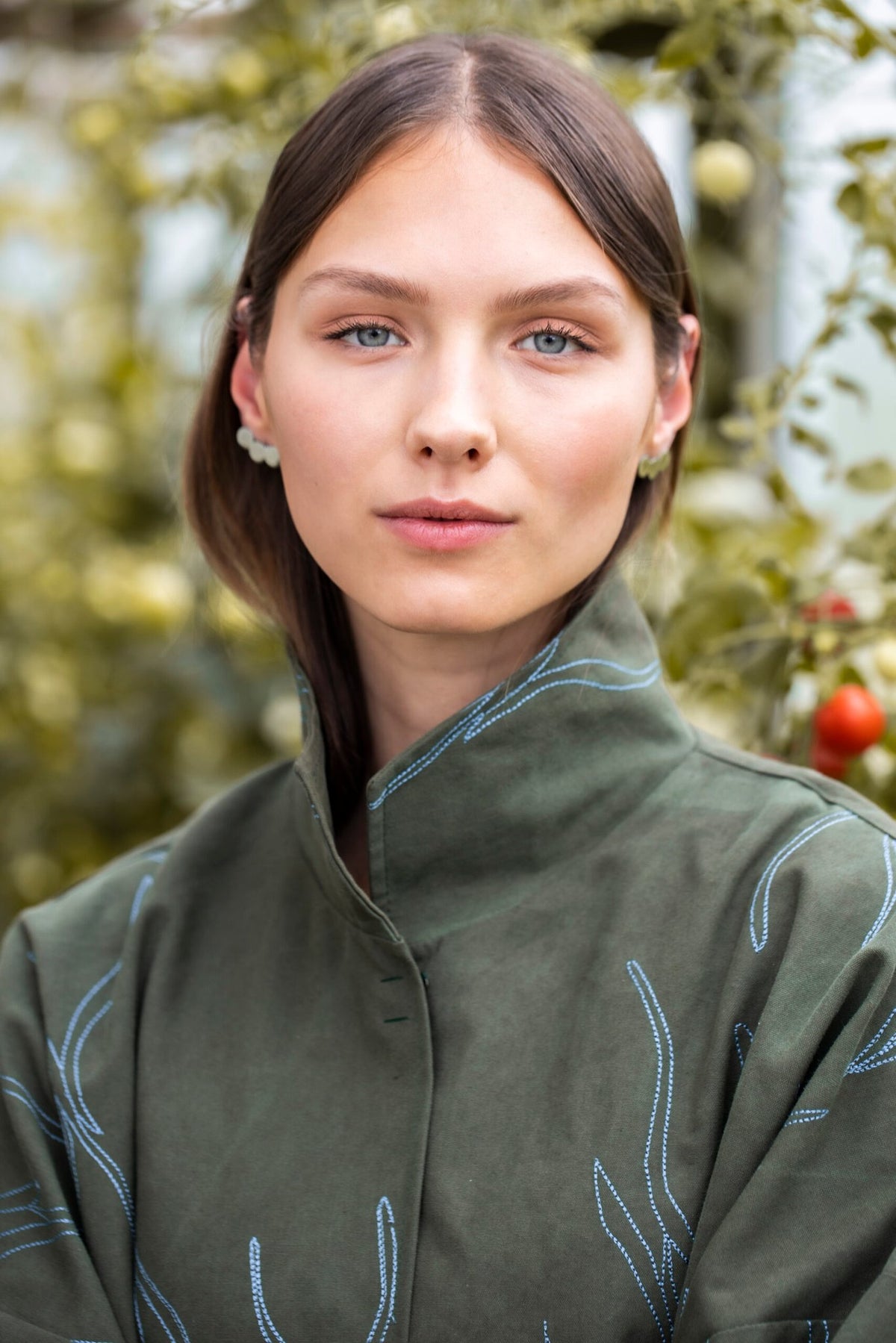 2. Close-up of woman wearing Lentsius Baca earrings, highlighting polished stainless steel and sustainable craftsmanship