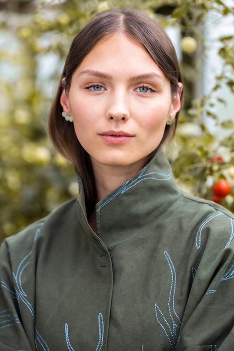 2. Close-up of woman wearing Lentsius Baca earrings, highlighting polished stainless steel and sustainable craftsmanship