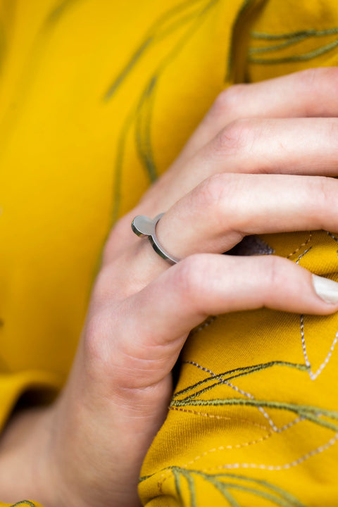 2. Close-up of Lentsius Cauda ring on woman's hand, highlighting polished edge and half-matte sides