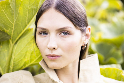 2. Close-up of woman wearing Lentsius Rubus earrings with a natural background