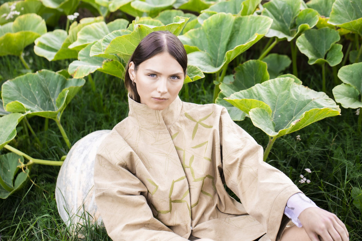 1. Woman wearing Lentsius Rubus earrings in a garden setting, showcasing Scandinavian style