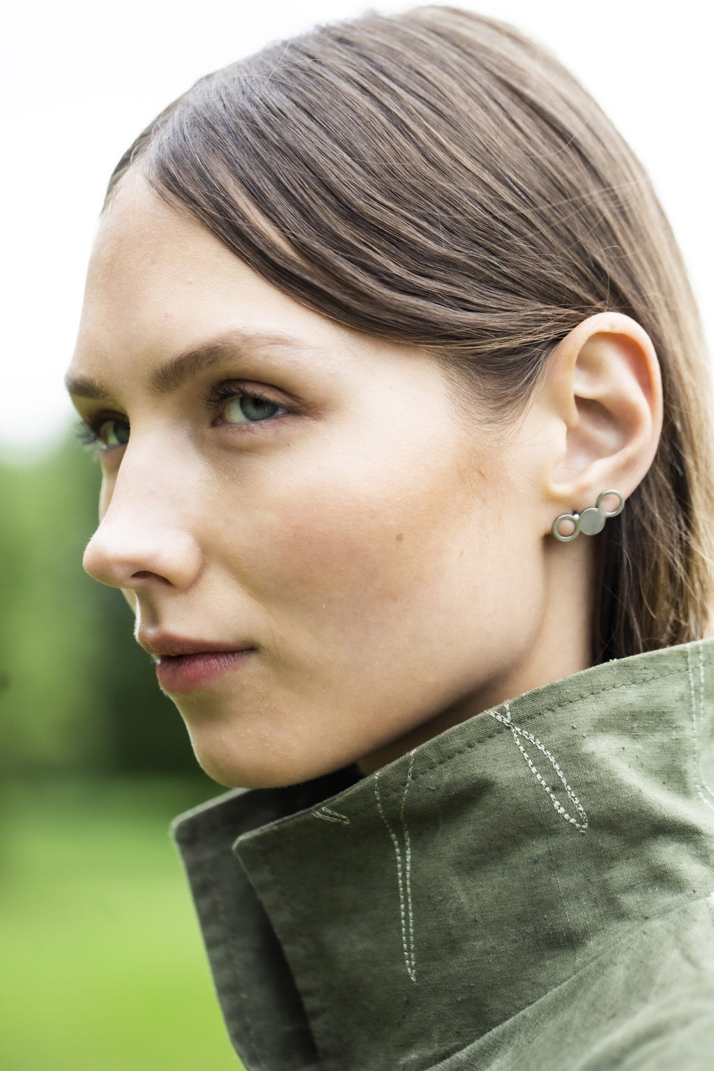 1. Woman wearing Lentsius Silva stainless steel earrings in outdoor setting
