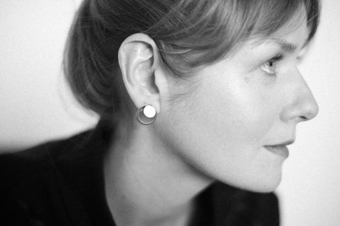 3. Side profile of woman wearing Lentsius Luna earrings, emphasizing polished stainless steel