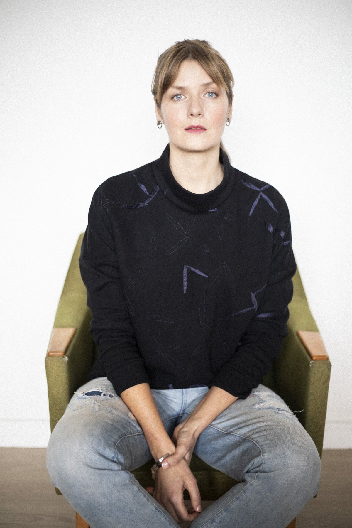 1. Woman wearing Lentsius Luna earrings, showcasing Scandinavian style in a casual setting