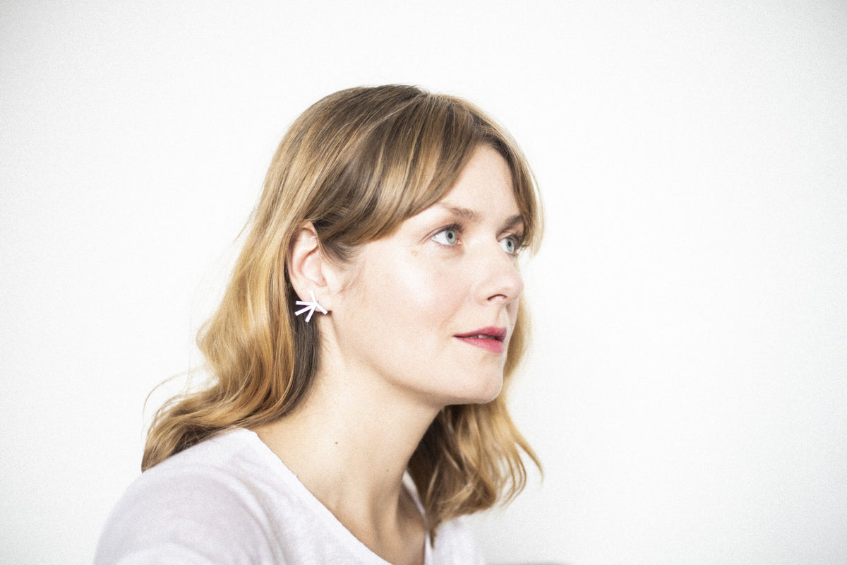 3. Side view of woman wearing Lentsius Stella earrings, emphasizing elegant design