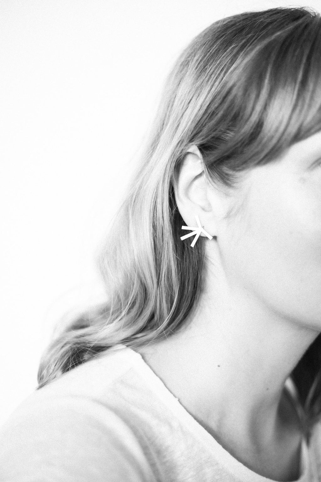 6. Close-up of Lentsius Stella earrings on woman, showcasing half-matte stainless steel finish