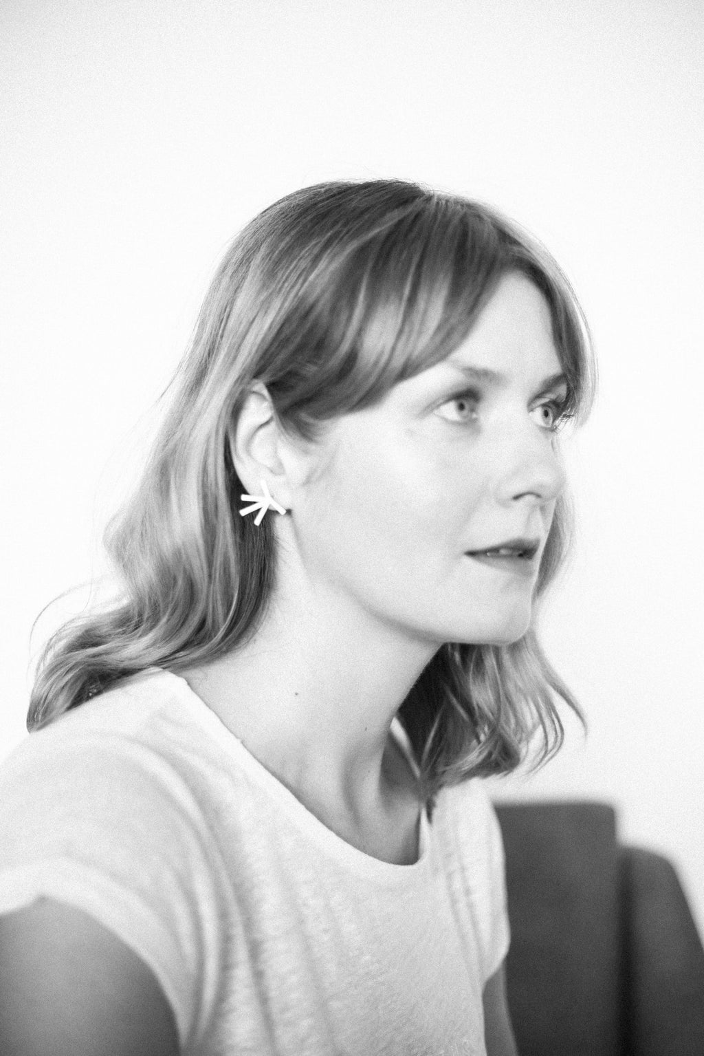 1. Woman wearing Lentsius Stella earrings, showcasing Scandinavian style in a lifestyle setting