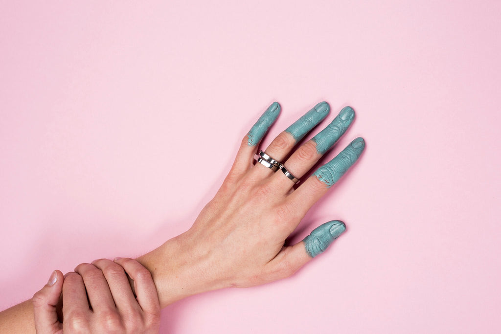 1. Women's hand wearing Lentsius Twins ring in stainless steel on pink background