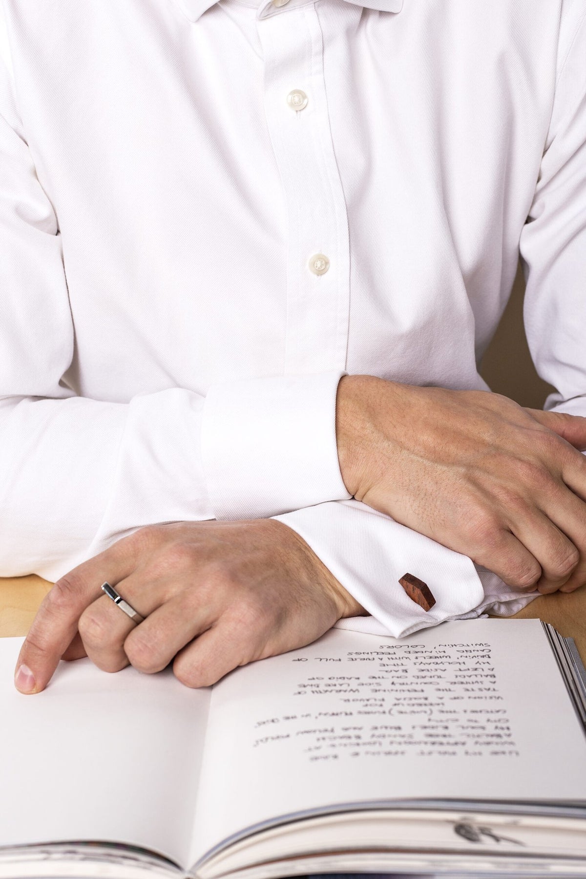2. Man wearing Lentsius Twins ring in stainless steel while reading a book