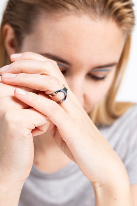 4. Woman with Lentsius Versus ring, focusing on unique design and Scandinavian elegance