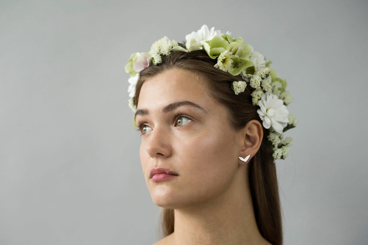1. Woman wearing Lentsius Vola silver earrings with floral headpiece, showcasing Scandinavian style