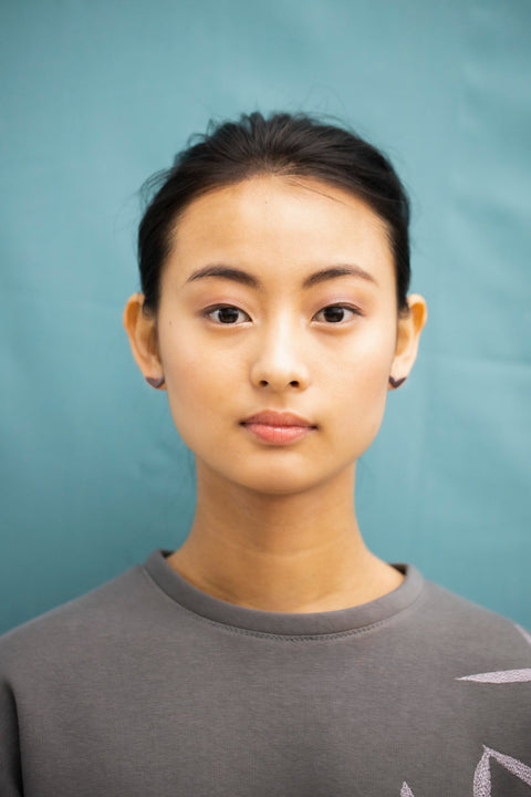 2. Front view of woman wearing Lentsius Vola purple earrings, highlighting eco-conscious design