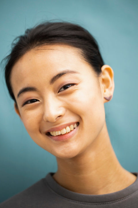 3. Smiling woman wearing Lentsius Vola purple earrings, emphasizing sustainable elegance