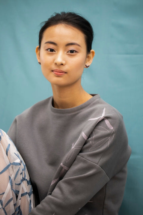 4. Woman seated wearing Lentsius Vola purple earrings, blending nature and style