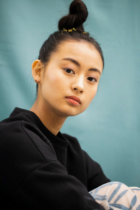 1. Woman wearing Lentsius Vola rose gold earrings, showcasing elegant design in lifestyle setting