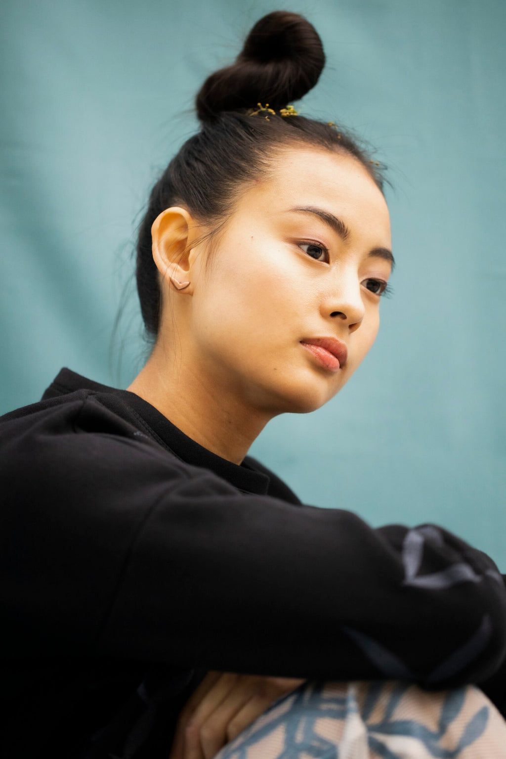 4. Woman in profile wearing Lentsius Vola rose gold earrings, showcasing minimalist design