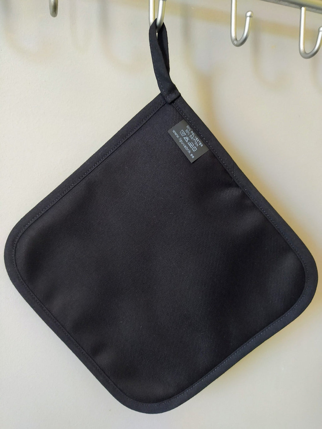 2. Black pot holder with a plain design, hanging on a metal hook, showcasing polyester and cotton blend material