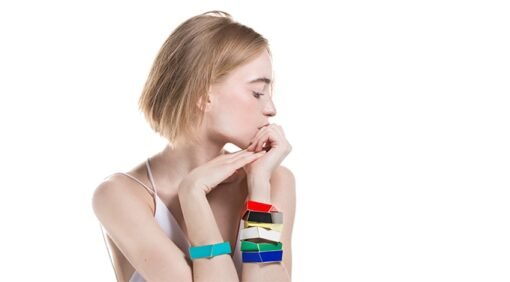 1. Woman wearing multiple Lisa Kroeber Jewellery Folded Bracelets in various colors, showcasing artisanal design